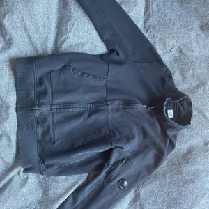 C.P Company Zip Sweatshirt - Köpt i Kauffman i Köpenhamn. Nypris: 2200 Sek. Finns ett stort hål nere vid högra ficka på tröjan och 2 väldigt små uppe vid kragen på vänster sida. Fläckarna som syns på bilden tages bort innan försäljning. Kan fraktas!