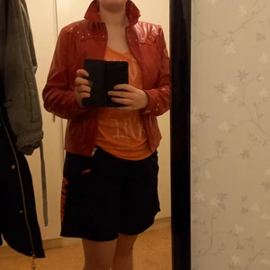 Skinnjacka röd med knappar  - Fin röd skinnjacka med dragkedja i fint skick inga hål, finns små fickor i jackan alltså inget fel på den
