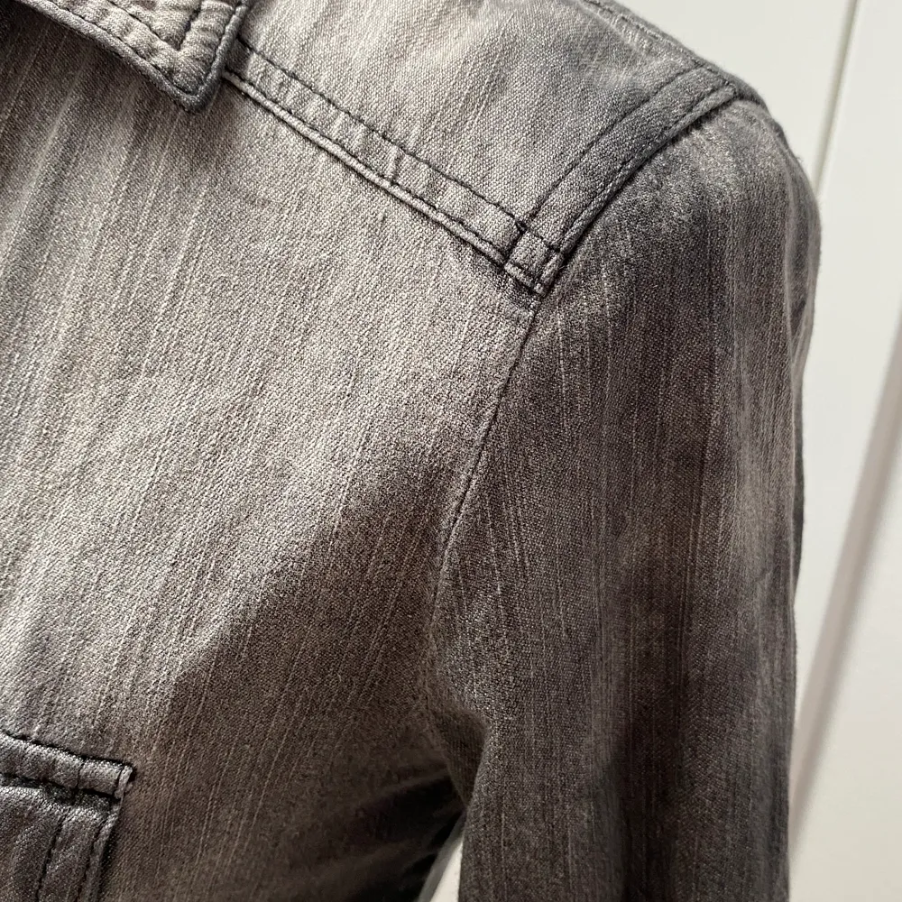 Snygg grå jeansskjorta med svarta knappar! Den ska sitta rätt tajt och passar dig som har storlel XS eller S. 😎 . Skjortor.
