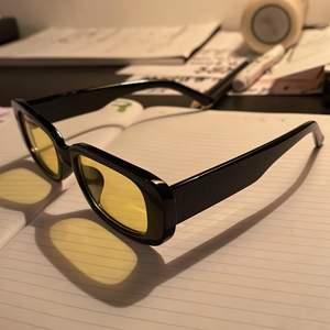 Solglasögon med gult glas och svart rak ram. Knappt använda, så gott som nytt skick! 