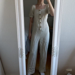 Jumpsuit i linne  - Beige jumpsuit i linne med fyrkantsringning, endast använd en gång så så gott som ny!