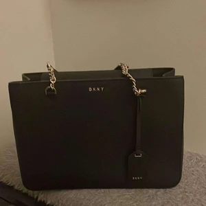 Väska dkny  - Äkta DKNY-väska i modellen Åhléns Shopper, färg svart. Väskan är i mycket gott skick, är köpt på NK och har dustbag. Använd 2-3 gånger. ❤️‍🔥