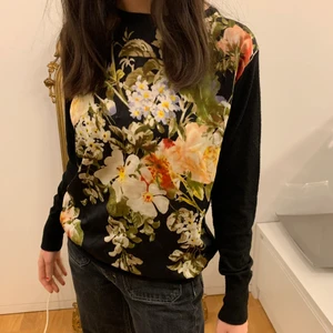 Blommig tröja🌼 - Så fin vårtröja! Vackra blommor på framsidan med svarta ärmar och svart rygg🖤🌼 Väldigt skön och elegant!