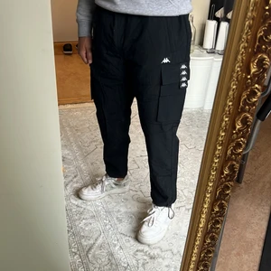 Kappa Cargo Byxor, Svarta Large - Säljer nu mina helt nya cargo byxor då det är inte min stil 🤷‍♂️, dem kostar ca 600kr på zalando. Ni får de helt oanvända för hälften av priset ;)
