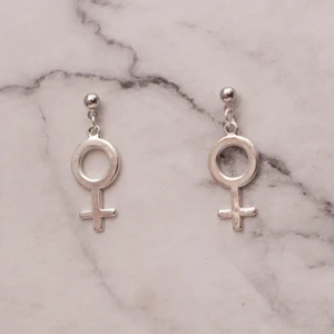 Örhängen med kvinnosymbol venus *Stor* - Fina silverfärgade örhängen med kvinnosymbolen. Stor symbol. Finns även med mindre symbol. Se bild nr 3 för storleksskillnad. Nickelfria. 