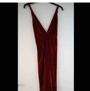 Röd Velvetklänning - Röd Velvetklänning med korsad rygg! Köpt second hand men är lite för stor i bysten för mig så skulle passa någon med lite större bröst.