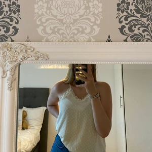 Gullig topp - Gulligt cremefärgat linne med glittriga prickar och volang. Endast använd en gång! Linnet är från Bikbok i storlek M. 