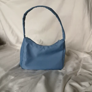 Gina blå axelremsväska  - En blå axelremsväska från ginatricot. Kostade 249 kr säljes för 125 kr. Använd 2 gånger exakt så som ny. Kan mötas upp i Halmstad eller frakta men köpare står för frakt💗