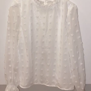Vit blus - Vit ”prickig” blus med fina ärmar och urringning. Storlek S. 