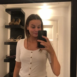 T-shirt med knappar - En vit super skön T-shirt med knappar😍 I storlek S men passar er med XS också. På grund av det stretchiga materialet så passar det även de med stor och liten byst💗