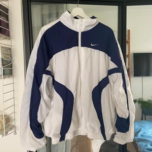 Vintage Nike Windbreaker - Vit/marinblå vintage Nike windbreaker. Dragkedja fullt fungerande. Inga fläckar eller hål. Står i storlek L men skulle säga M/L. Oavsett ”oversized” i sin passform. Skriv vid funderingar ☺️