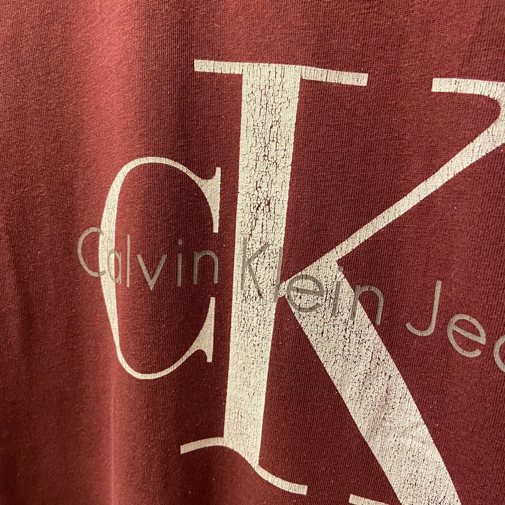 Fin och praktisk t shirt från Calvin Klein. Trycket på tröjan är lite slitet men annar i bra skick ❣️. T-shirts.