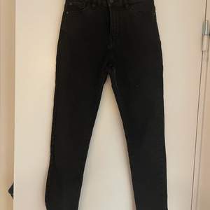 Ett par svarta och tajta jeans från Lindex i storlek 140 