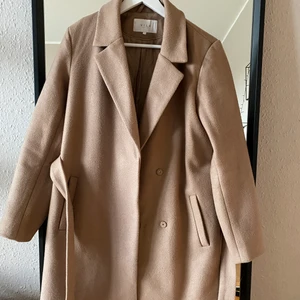 Kappa från VILA - kappa från Vila i färgen camel och storlek 38. Den är använd men i bra skick utan fläckar och skador. 