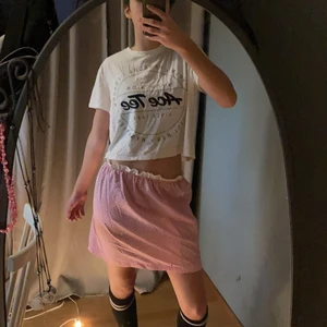 Magtröja  - Vit tröja med svart tryck, sitter löst och lite ovanför magen 