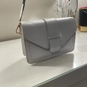 Vit axelväska  - Säljer min vita axelväska. Formad som ett kuvert nästa . Super smidig o rätt rymlig för den storleken. Aldrig använd 