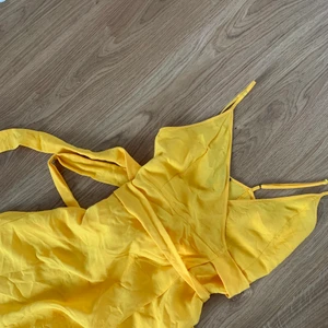 Klänning, S - Omlottklänning som slutar under knäna på mig som är 162cm. Färgen är lite mer klargul än vad som syns på bilden. Superhärligt nu till sommaren 