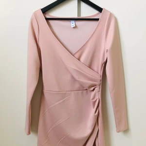 Puderfärgad omlottklänning  - Puderfärgad figurnära omlottklänning från NLY One.