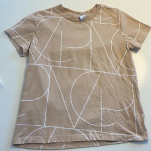T-shirt - Beige t-shirt med vita sträck på från MQs märke visual clothing project som utgått. Om flera t-shirts eller annat vill köpas så slås frakten ihop till en istället för flera olika