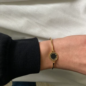 Marc Jacobs armband  - Ett stål armband i guld och svart från Marc Jacobs. Storleken passar nästan alla, stilrent och snyggt. Knappt använd, väldigt bra skick. Köpt på Jackie . Säljs till högsta bud + frakt 