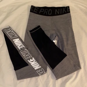 Träningstights Nike - Gråa träningstights från Nike med nikeloggan på insida lår. Säljer för att jag ej fått så mycket användning för de, i superfint skick! (Pris kan diskuteras) Skicka meddelande vid frågor/intresse💖