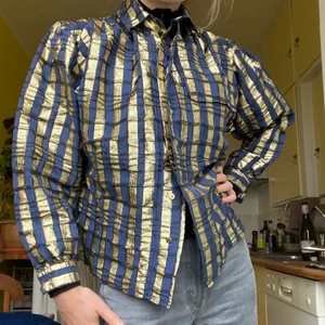 Randig Skjorta - Kunglig skjorta i mörkblått och guld! Markerade axlar! Sitter bra på mig som är S! 