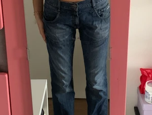Lågmidjade blå jeans med coola fickor. - Raka jenas med coola fickor på rumpan, lite bredare mudd i midjan som e jätte snygg. Även balla sömmar på benen 