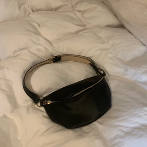 Handväska svart - Säljer min svarta handväska för använder ej längre. Superfin med guldiga detaljer. Dragkjedjans dragare lossnade men den funkar fortfaarande att öppna och stänga bra (andra bilden). Väskan är justerbar och har en praktisk ficka inuti som man ser på tredje bilden. 💓