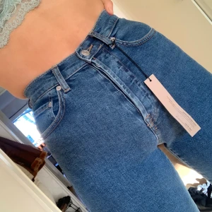 Jeans från NA-KD - Ett par helt oanvända jeans från NA-KD Supersnygga men tyvärr lite för tighta i midjan på mig, prislapp och allt sitter kvar. Momjeans som är mörkblåa. Mitt pris 300. Orginalpris 499 kr. Jag är 175 cm. 