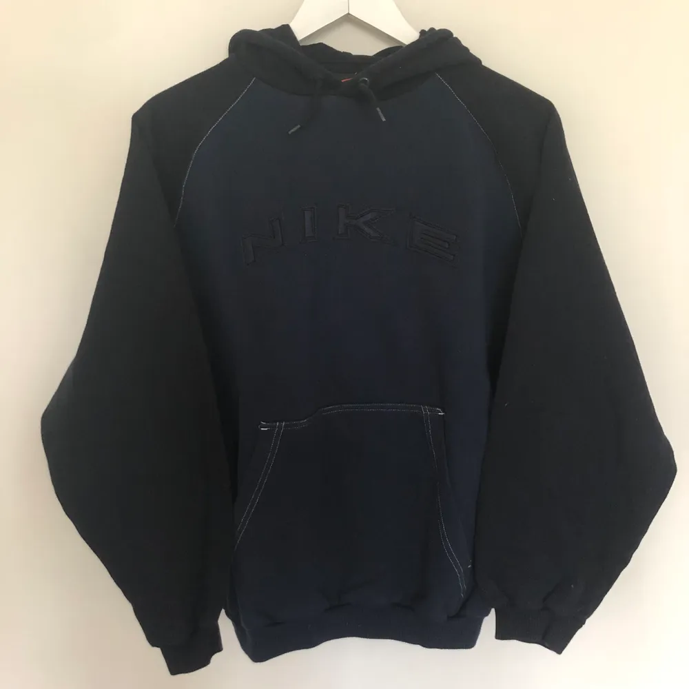 Vintage nike hoodie från 90-talet. Hoodien är i mörkblå och svart färg. Den har en riktigt najs Nike logga och har en boxy passform.. Hoodies.