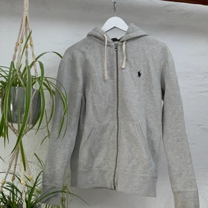 Ralph Lauren hoodie - Snygg grå hoodie från Ralph Laruren i strl s. Använd vid 3 tillfällen. OBS: Defekt i form av tråd som gått upp se bild 3 (går lätt att fixa med mål och tråd för hand/alt sömmerska). Nypris 1395kr🤍