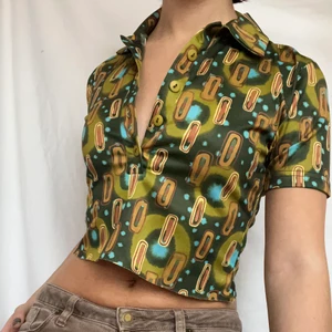 Kortärmad retro skjorta  - Cool kortärmad skjorta med lite retro-vibe! Köpare står för 51kr spårbar frakt. Visas på en s men passar även xs. Avklippt nertill men tyget är ej sådant att det behöver bli insytt där. 