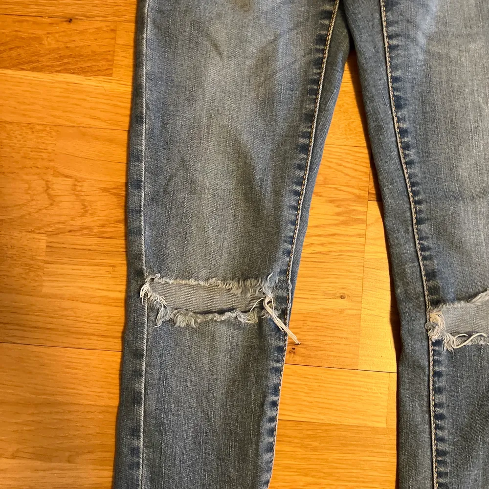 Ljusblåa tighta jeans, högmidjade med slitningar i knäna.. Jeans & Byxor.