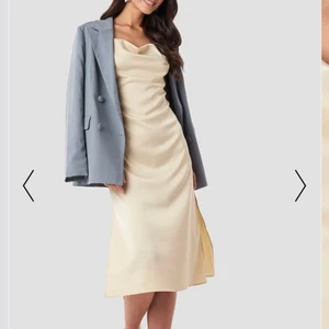 NA-KD satinklänning i champagne - Säljer denna jättefina klänning, som köptes för 2 år sen och har använts en gång, för att storleken inte passar mig. Den är alltså knappt använd och i jättebra skick. Nypris 499 kr.