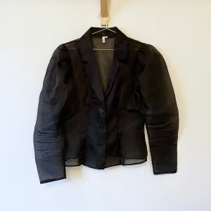 Blus i tyll - En svart blus från NAKD i tyll. Storlek M. En knapp längst ner saknas.