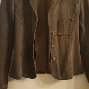 Grön stilig figursydd kavaj - Ny figursydd kavaj med små fina detaljer, knappar, dragkedja, liten ficka. Storlek small. Köparen står för frakt, spårbart 66 kr