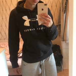 Under Armour Hoodie - Svart Under Armour hoodie i gott skick! Säljer eftersom jag inte använder den eftersom jag helst inte bär märkeskläder. 90kr med inräknad frakt! Inga slitningar, trycket är helt osv, felfri! Vanlig i storleken.  Betalning sker via Swish!