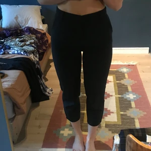 Mörkblåa byxor  - Mörkblåa byxor i viskos som är vadlånga. Sitter jättebra på. Höga :) lite plisserade. Från bikbok