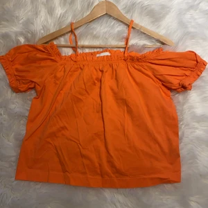 Offshoulder topp från hm  - En snygg orange offshulder topp från hm. Helt oanvänd och mycket fin orange färg som passar perfekt till nu i sommar. 