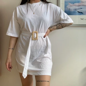 T-shirt klänning storlek 36 - Vit T-shirt klänning med skärp i midjan som går att reglera själv,  helt oanvänd med prislapp kvar. Frakt ingår ej i priset. 