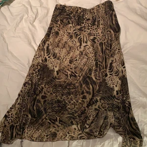 Kjol med leopardmönster - Em super söt lång kjol som går typ till vaderna på mig som är 170. Med leopardmönster och en liten kort slits! 