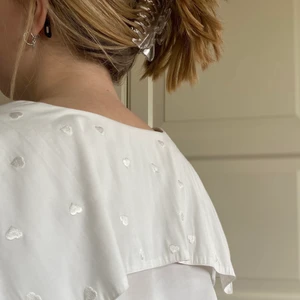 Vintage blus - En supersöt vintage blus med broderade hjärtan!! Den är i väldigt fint skick och har inte en enda fläck. Passformen är bra och tyget är behagligt. Ifall man är intresserad av få mer liv i den kan man sy in axelvaddar, då det en gång funnits i den:) FRAKT INGÅR!!!