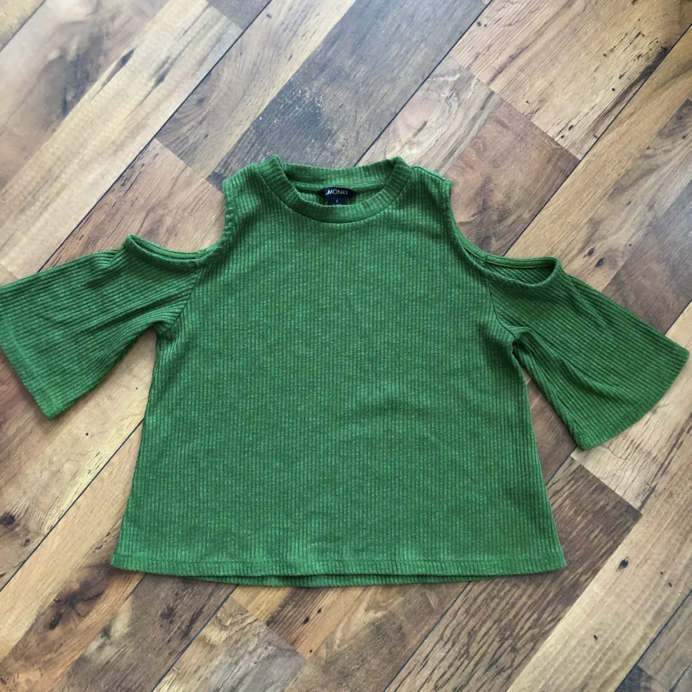 Croppad grön t-shirt från Monki med cut-out på axlarna. Skön med bra passform. Säljes endast för att jag inte använder den längre.. T-shirts.