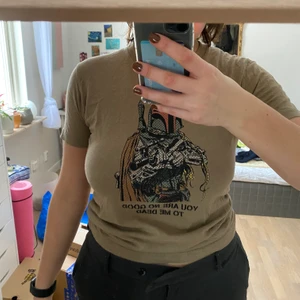 Baby tee med starwars tryck  - En ascool baby tee i en skogs grön färg med ett starwars tryck på. Passar as bra med lågmidjade jeans eller liknande. 