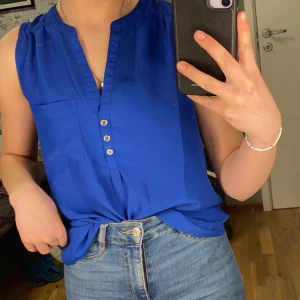 H&M blus storlek 34 - Blå blus med urringning från H&M. Använd men i bra skick.