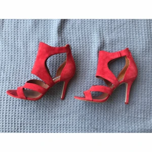 Korallröda röda sandaletter högklackat äkta mocka från & Other Stories strl 40 - Supersnygga korallröda röda sandaletter i äkta mocka från & Other Stories, strl 40. Använda ett par gånger och säljer eftersom de inte kommer till användning. I jättefint skick, bara en fläck på ena klacken som säkert går bort med mockaborste (se bild 3) annars inget att anmärka på.