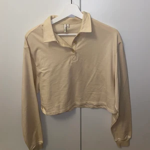 Sweatshirt med krage - Croppad sweatshirt med krage i beiget från Nelly i storlek XS