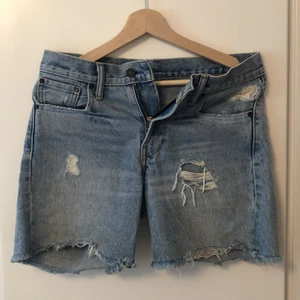 Levis mom shorts - Shorts i ljus denim med slitningar i fram. Mom-modell, storlek 27. 200kr, köparen står för frakten