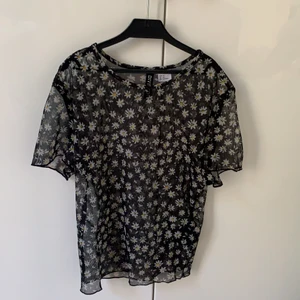 Blommig topp - Säljer denna topp från hm då den inte kommit till andväning. Tyget är transparent och är i storlek xs. Köparen står för frakten. 