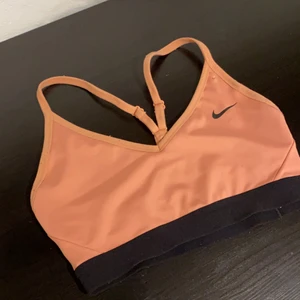 Nike sport-bh  - Läger ut denna på nytt eftersom att köparen inte ville svara. Nike sport-bh/topp (w indy bra). Rosa/aprikos färg. Light support. Inlägg följer med men kan tas ut om man så vill det. Använd men i fint skick. Stl S. Skickas med postnord 🤍🤍